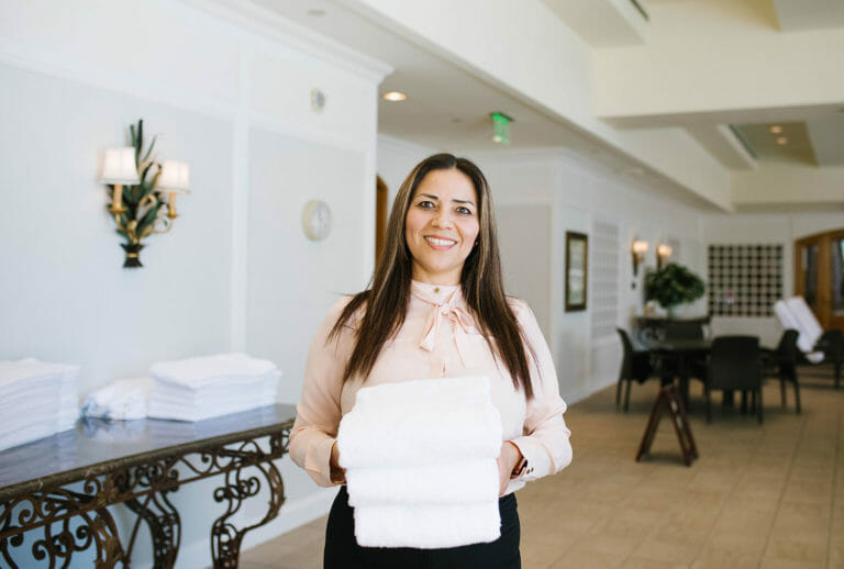 Little America Hotel employee holding towels in the indoor pool area