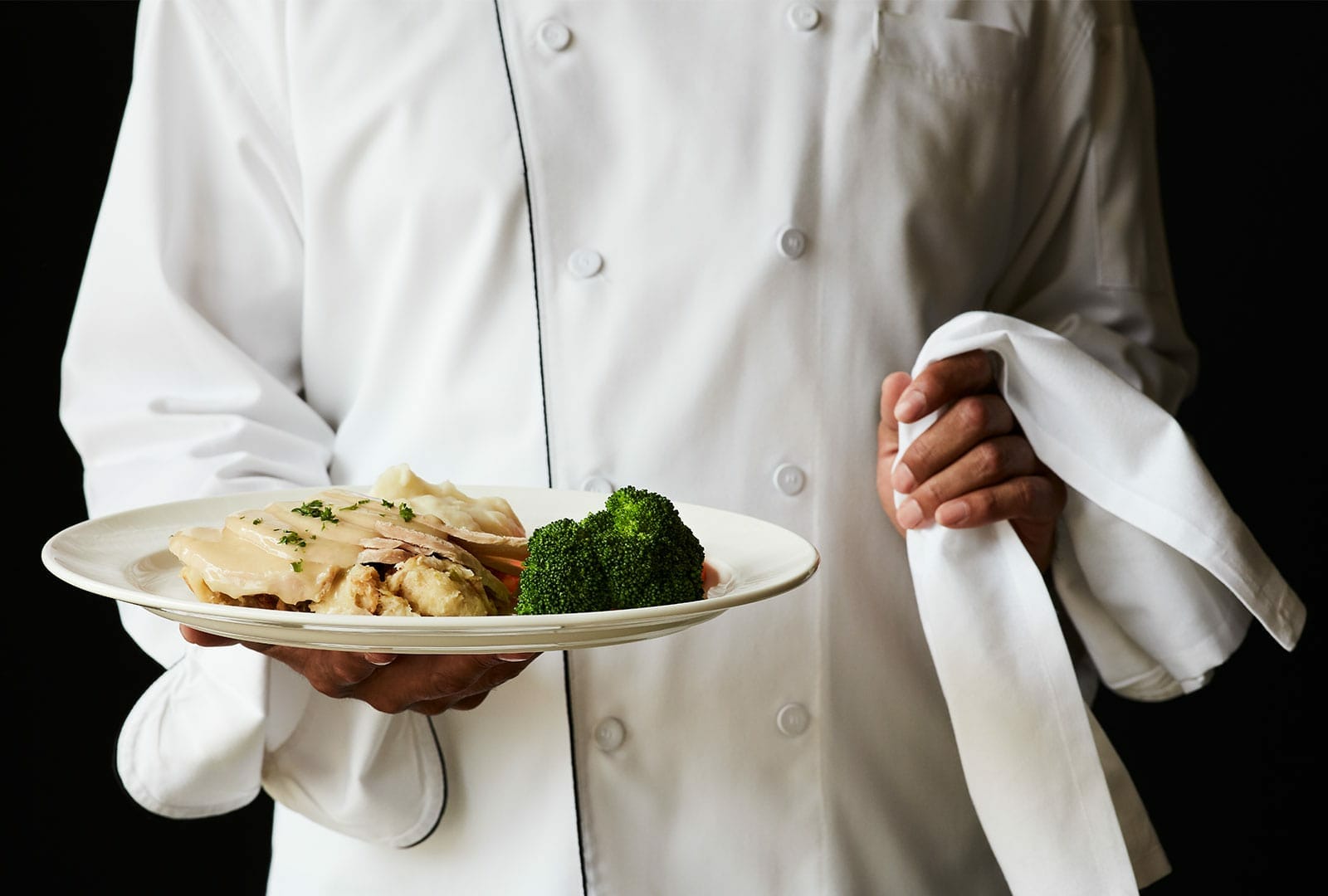 Little America Chef holding a plate of Thanksgiving Dinner