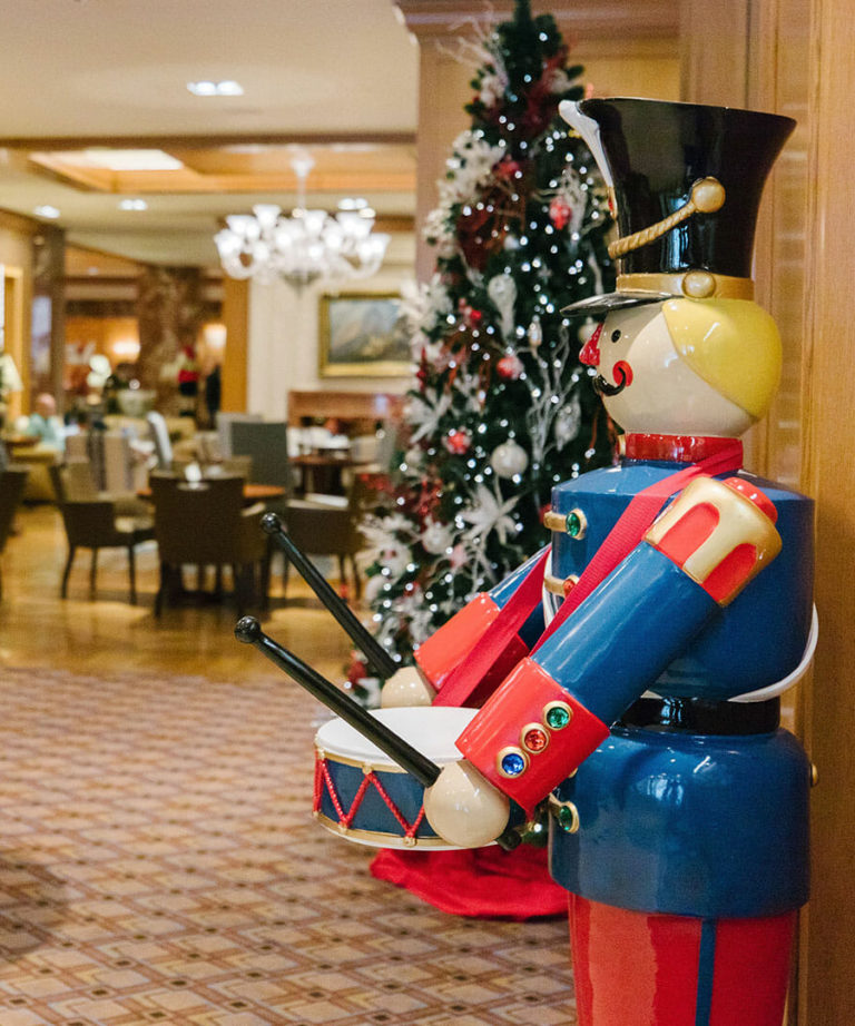 Life-size nutcracker and Christmas tree decorations in the Little America Lobby Lounge