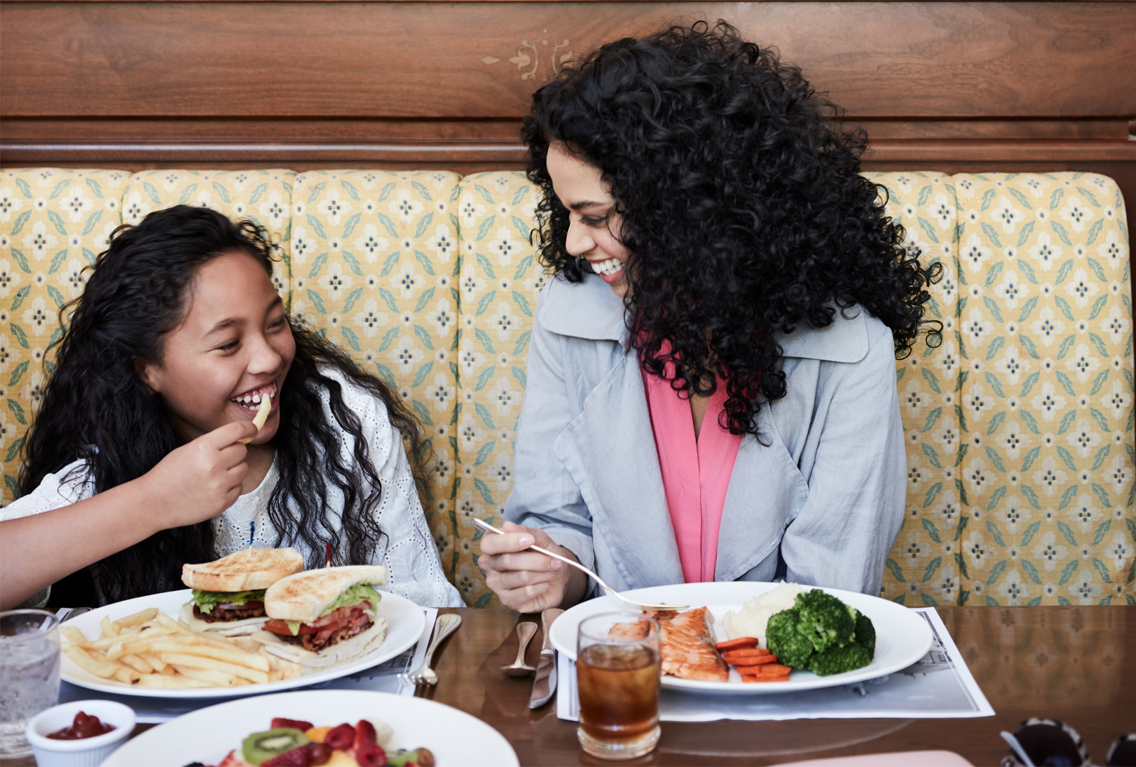 Mom and daughter eating lunch in booth at the Little America Hotel.