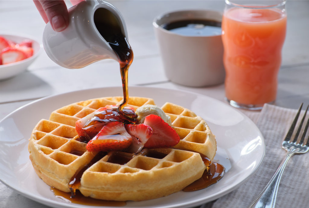 Close up of syrup being poured on waffle at the Little America Hotel Coffee Shop.