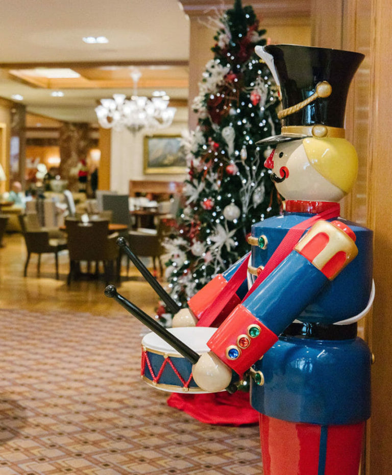 Life-size nutcracker and Christmas tree decorations in the Little America Lobby Lounge